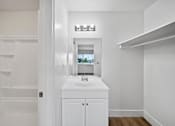Thumbnail 12 of 17 - A white bathroom with a sink and mirror.