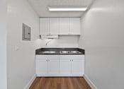Thumbnail 14 of 17 - A kitchen with white cabinets and a black countertop.