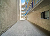 Thumbnail 5 of 12 - A long, narrow alleyway between two buildings with balconies on the upper floors.