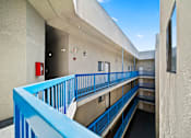 Thumbnail 6 of 12 - A blue railing on a balcony overlooks a courtyard.