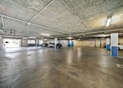 Thumbnail 7 of 12 - A large, empty parking garage with concrete floors and walls.