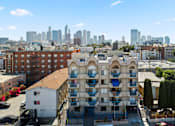 Thumbnail 1 of 12 - A building with a balcony in front of a city skyline.