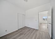 Thumbnail 9 of 12 - A room with a white door and a window.
