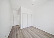 Thumbnail 11 of 12 - A room with a white door and a white wall.