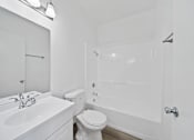 Thumbnail 12 of 12 - A white bathroom with a toilet, sink, and bathtub.