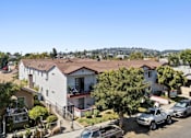 Thumbnail 1 of 12 - A sunny day in a residential area with houses and parked cars.