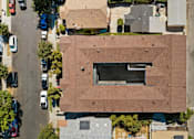 Thumbnail 4 of 12 - A building with a large window is surrounded by cars and other buildings.