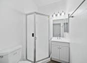 Thumbnail 6 of 12 - A white bathroom with a tub, sink, and medicine cabinet.