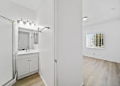 Thumbnail 7 of 12 - A white bathroom with a sink and a mirror.