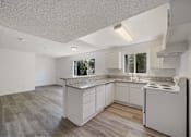 Thumbnail 11 of 15 - A kitchen with white cabinets and a granite countertop.