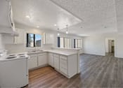 Thumbnail 14 of 15 - A kitchen with white cabinets and a stove top oven.