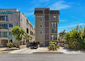 Thumbnail 2 of 15 - A modern apartment building named South Towers is shown with a clear blue sky in the background.