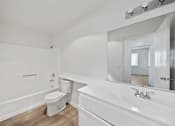 Thumbnail 17 of 18 - A white bathroom with a toilet, sink, and mirror.