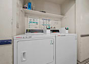 Thumbnail 10 of 10 - A Washing Machine and Dryer are in a small room.