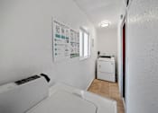 Thumbnail 9 of 10 - A white wall with a poster titled "Making Layers Fun" and a white washing machine.