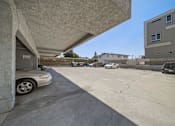 Thumbnail 7 of 10 - A parking lot with cars and a building in the background.
