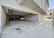 Thumbnail 5 of 10 - A concrete garage with a white car inside.