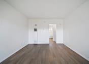 Thumbnail 16 of 20 - A room with white walls and wood flooring.