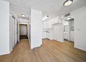 Thumbnail 12 of 33 - A kitchen with white cabinets and a wooden floor.