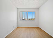 Thumbnail 14 of 33 - A room with a window and wooden floor.