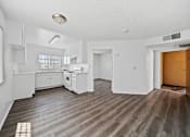 Thumbnail 17 of 33 - A kitchen with white cabinets and a wooden floor.