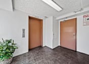 Thumbnail 7 of 33 - A room with two elevator doors and a sign on the wall.