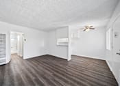 Thumbnail 16 of 30 - A room with a ceiling fan and a door leading to another room.