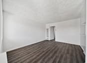 Thumbnail 22 of 30 - A room with a wooden floor and white walls.