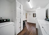 Thumbnail 25 of 30 - A white laundry room with a washer and dryer.