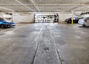 Thumbnail 7 of 30 - A parking garage with a blue car on the left and a silver car on the right.