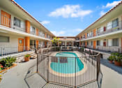 Thumbnail 12 of 30 - A pool surrounded by a fence in a courtyard.