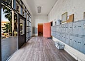 Thumbnail 10 of 29 - A long hallway with a row of lockers on the right and a door at the end.
