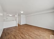 Thumbnail 18 of 29 - A room with wooden flooring and white walls.