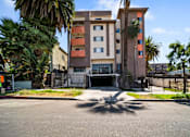 Thumbnail 1 of 29 - A multi-story building with a parking lot in front.