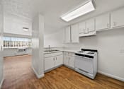 Thumbnail 23 of 29 - A kitchen with white cabinets and a stove top oven.
