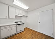 Thumbnail 24 of 29 - A kitchen with white cabinets and a stove top oven.