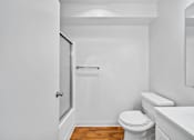 Thumbnail 29 of 29 - A white bathroom with a toilet, sink, and mirror.