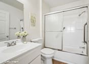 Thumbnail 3 of 21 - A white bathroom with a toilet, sink, and shower.