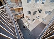 Thumbnail 10 of 21 - A view from above of a courtyard between two buildings with a small tree and a planter.