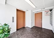 Thumbnail 7 of 21 - A hallway with two doors and a sign that says "Elevator".