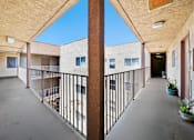 Thumbnail 9 of 21 - A long hallway with a balcony on the left side.