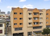 Thumbnail 5 of 21 - A large building with a yellow and orange facade.