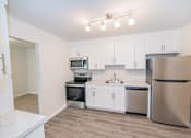 Thumbnail 8 of 11 - A kitchen with white cabinets and stainless steel appliances at Kings Gate West Apartments, New York, 13031