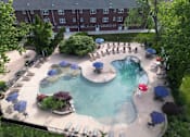 Thumbnail 15 of 22 - A large outdoor swimming pool surrounded by chairs and umbrellas at Rivercrest Apartments, Piscataway , NJ, 08854