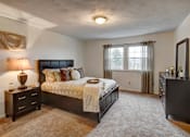 Thumbnail 9 of 11 - A bedroom with a large bed and a nightstand with a lamp at Kings Gate West Apartments, New York