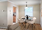 Thumbnail 7 of 22 - A dining room with a glass table and white chairs at Rivercrest Apartments, Piscataway