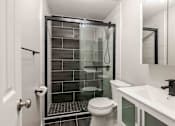 Thumbnail 7 of 13 - A white toilet sits next to a walk-in shower in a bathroom at Seaview Apartments in Staten Island, NY, 10305