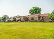 Thumbnail 19 of 21 - A row of houses with a green field.
