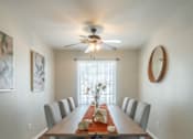 Thumbnail 47 of 48 - A long wooden dining table with chairs and a fan on the ceiling.