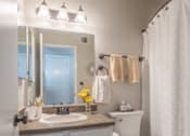 Thumbnail 45 of 48 - A bathroom with a white toilet, sink, and a white shower curtain.